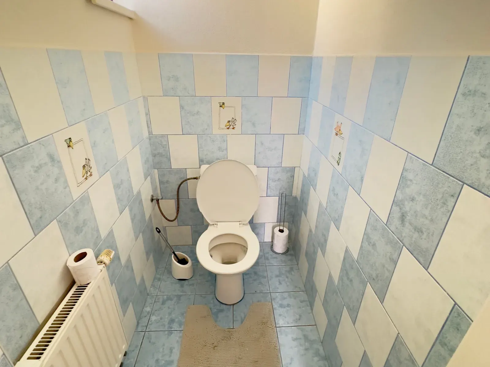 Toaleta s původními modrými obklady před rekonstrukcí